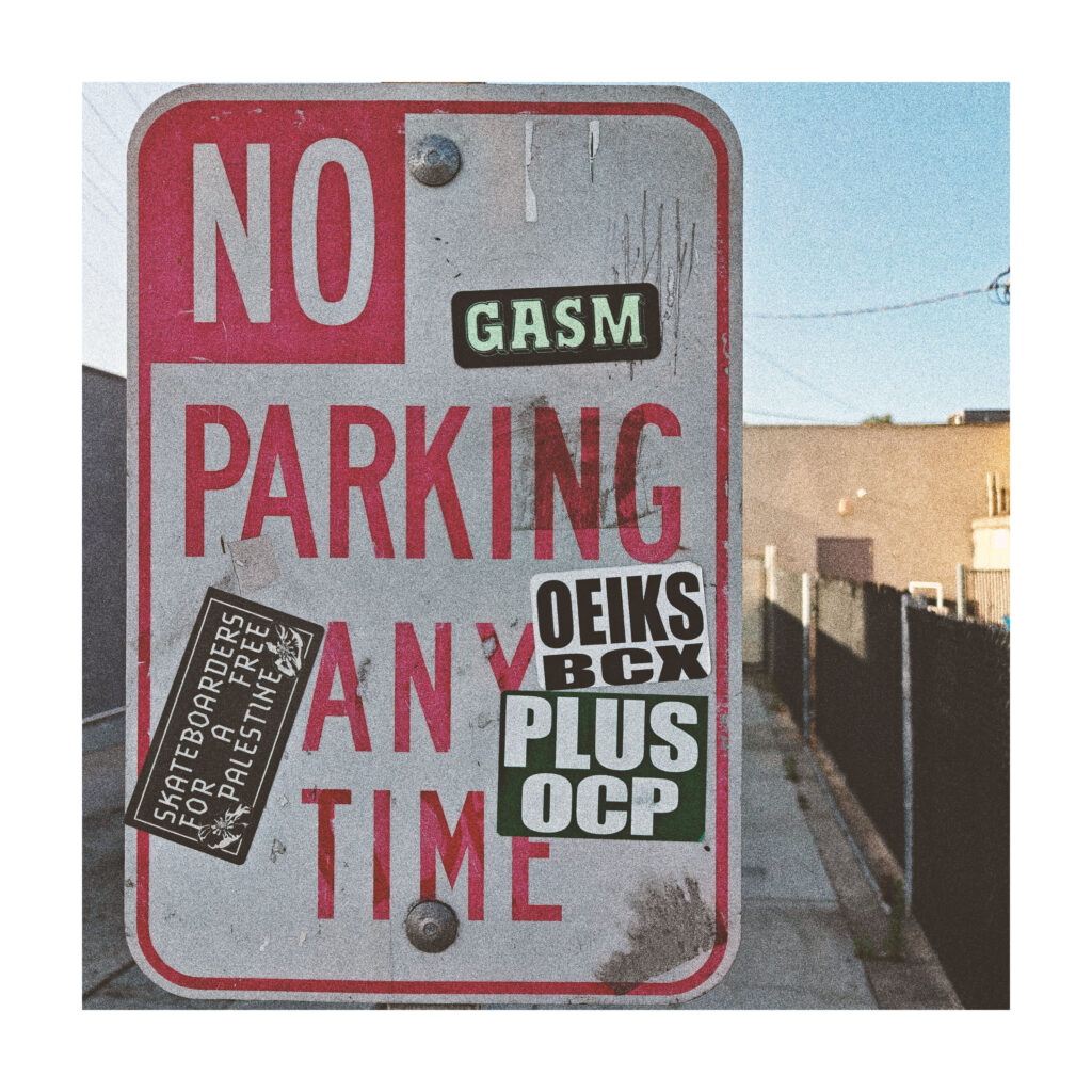 A no parking sign with various stickers. A sticker with the name GASM sits at top right.