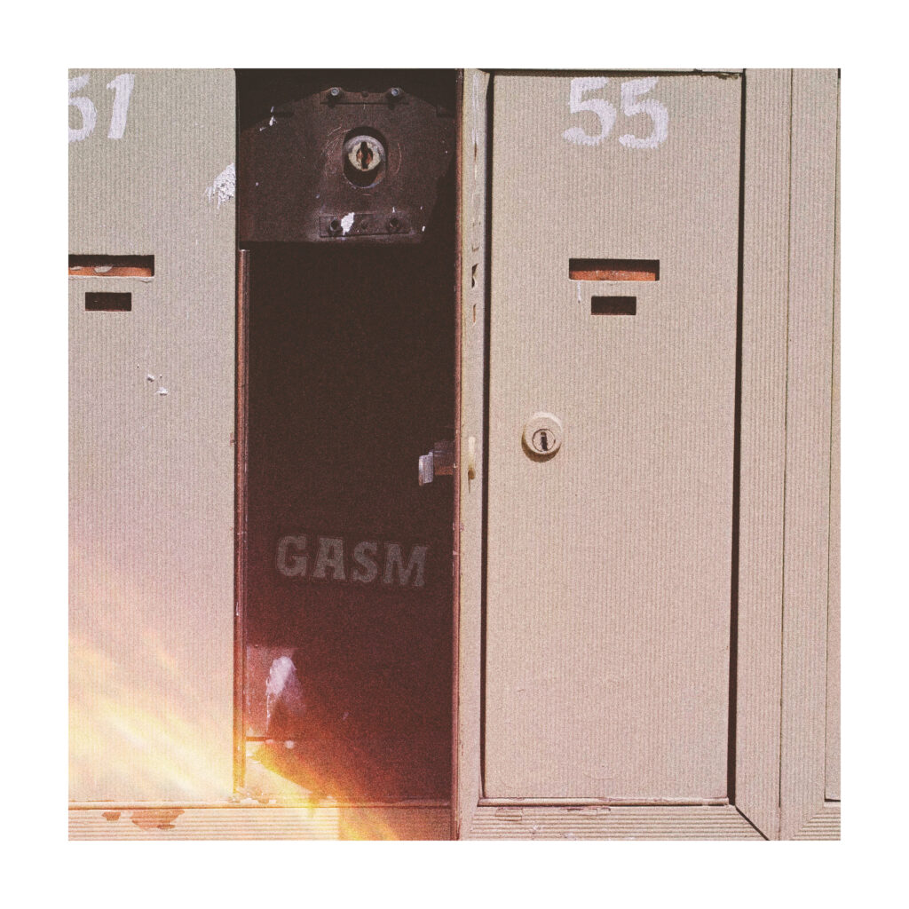 There is one open mailbox in between two closed mailboxes. The open mailbox has a sticker with the name GASM hidden inside.